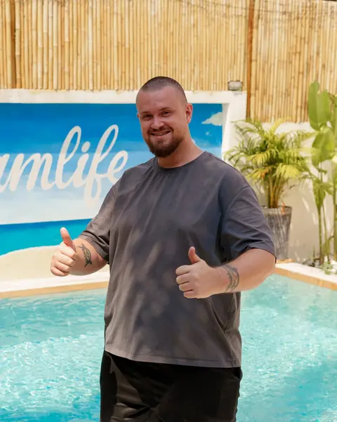 Nico, Gründer von Dreamlife.now, zeigt am Pool zwei Daumen nach oben